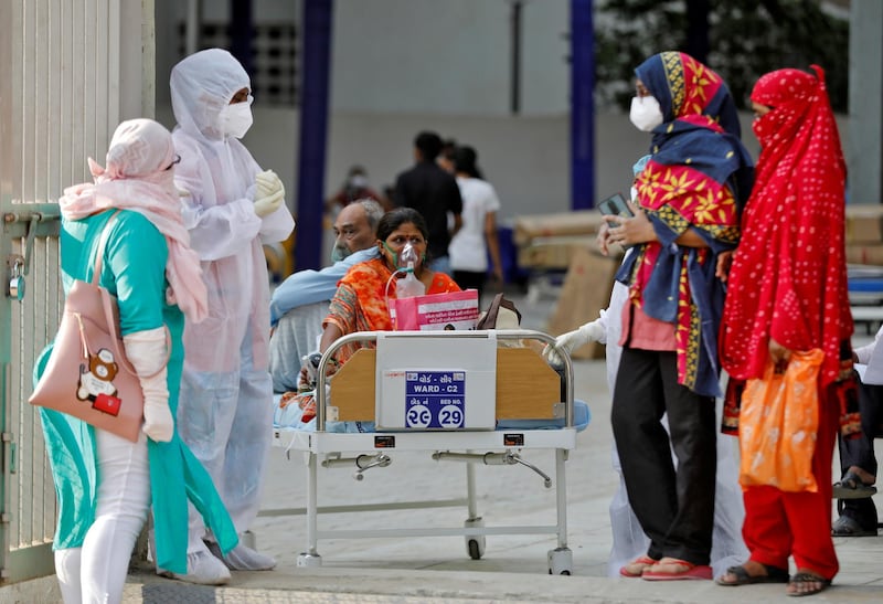 Patients sit on bed waiting to be moved to a hospital, amid the spread of the coronavirus disease in Ahmedabad, India. Reuters