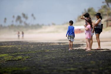 Tourists are seen near an oil spill on 'Sitio do Conde' beach in Conde, Bahia state, Brazil. REUTERS/Adriano Machado