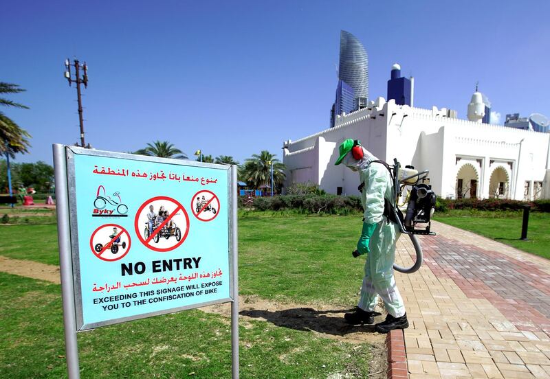 Abu Dhabi, United Arab Emirates, March 25, 2020. 
  Standalone:
A Tadweer sanitary worker sprays the Family Park at the Corniche with disinfectants to counter the spread of the coronavirus.
Victor Besa / The National
Section:  NA
Reporter: