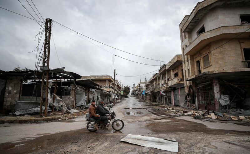 Syrians ride a motorbike in the deserted city of Kafranbel, south of Idlib city in the eponymous northwestern Syrian province. AFP