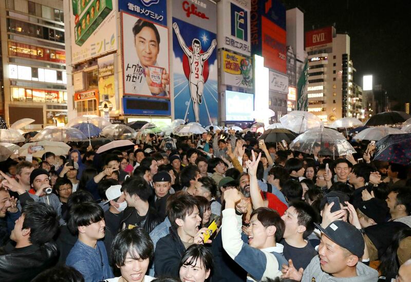 People celebrate as new Emperor Naruhito's era of Reiwa, or "beautiful harmony" began early Wednesda, in Osaka, western Japan.  Emperor Akihito announced his abdication at a palace ceremony Tuesday in his final address. AP