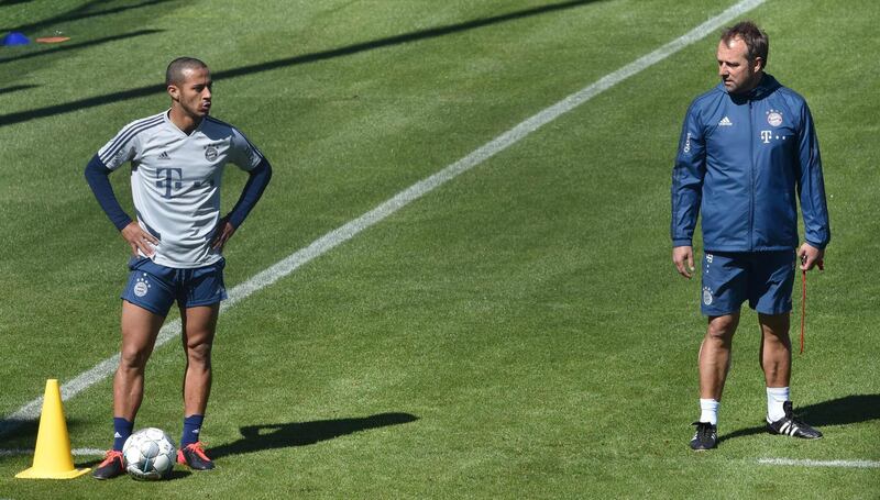 Bayern Munich's German head coach Hans-Dieter Flick (R) speaks with midfielder Thiago Alcantara. AFP