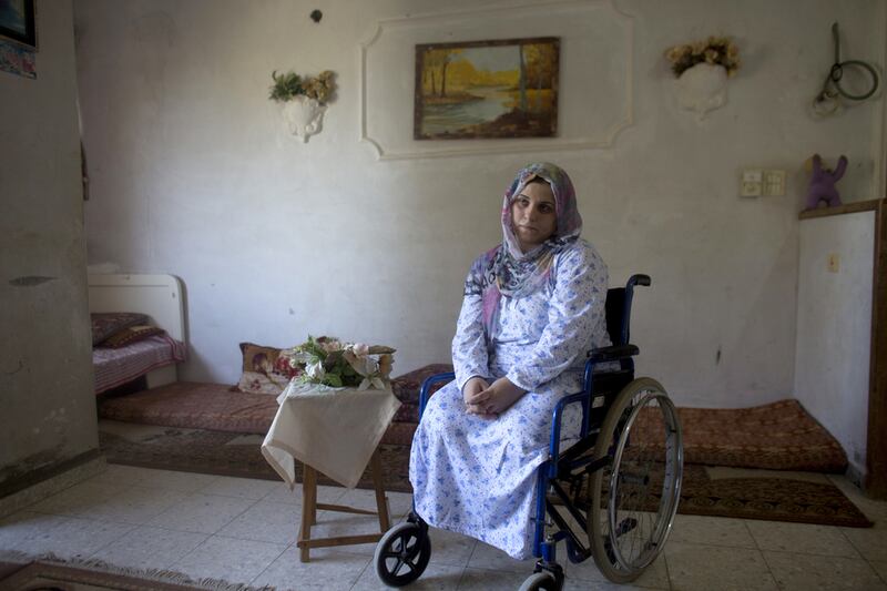 Wounded Palestinian woman Asraah Al Namla , a married woman and mother of two at her parents home in Gaza City on July 3,2015. Azreen lost both of her legs during last summer’s 50 day war between Israel and the Hamas -controlled Gaza Strip Her husband Wael lost  his legs, and their son Shareef lost the lower part of his  leg . The incident happened on one of the darkest days during the war that has been named ‘Black Friday’ .Palestinians claim 130-150 were killed  in the Rafa area of southern Gaza during a breakdown of a cease fire agreement during a tunnel incident between Hamas and Israeli troops .The family was fleeing on foot trying to reach a safer area when an Israeli  rocket attack hit them . Wael’s 11 -year old sister and his brother Yusef and his wife were killed . Heidi Levine for The National