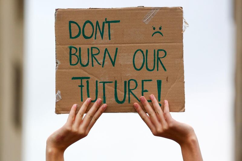 BERLIN, GERMANY - SEPTEMBER 25: A demonstrator holds a banner reading 'Dont burn our future' as climate activists gather on a "Global Day of Action" organized by the Fridays for Future climate change movement during the coronavirus pandemic on September 25, 2020 in Berlin, Germany. Activists are taking to the streets across the globe today in the largest climate change protest day since the beginning of the pandemic. They are demanding immediate and global shifts in policies in order to rein in the effects of human-induced global warming. (Photo by Omer Messinger/Getty Images)