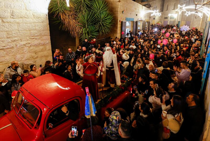 Palestinians dressed as Santa Claus and Mrs Claus lead festivities in Bethlehem. Reuters