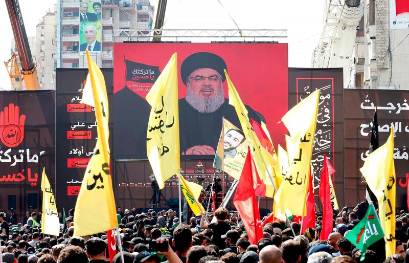Supporters of Lebanon's Shiite movement Hezbollah gather near a giant poster of their leader Hassan Nasrallah during a ceremony to mark Ashura on September 20, 2018 in Beirut. Ashura commemorates the death of Imam Hussein, grandson of the Muslim faith's prophet Mohammed, who was killed by the armies of his rival Yazid over the succession for the caliphate near Karbala in 680 AD. / AFP / ANWAR AMRO
