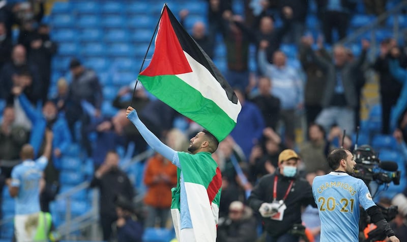 Riyad Mahrez with the Palestinian flag during the Premier League trophy presentation on Sunday. EPA