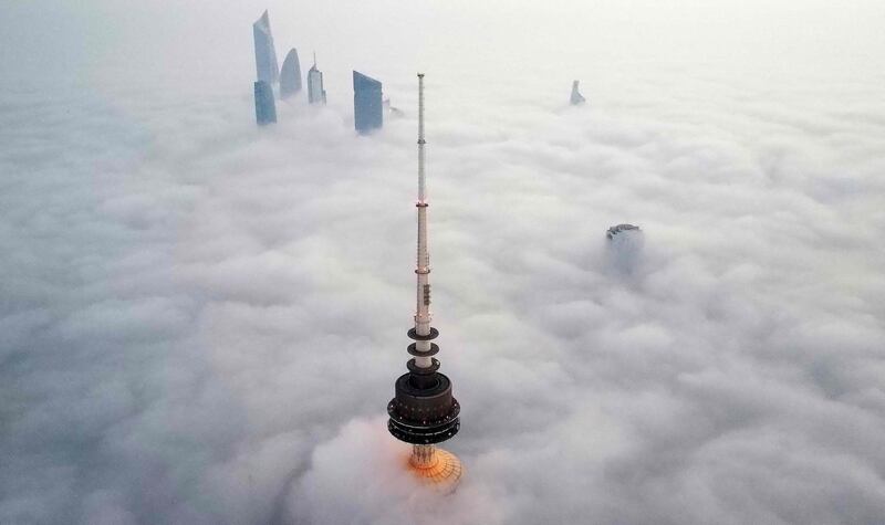 This aerial picture shows a view of Liberation tower (front) amid heavy fog in Kuwait City, early on January 21, 2023.  (Photo by YASSER AL-ZAYYAT  /  AFP)