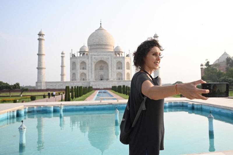 Melissa Dalla Rosa from Brazil takes souvenir photos at the Taj Mahal. AFP