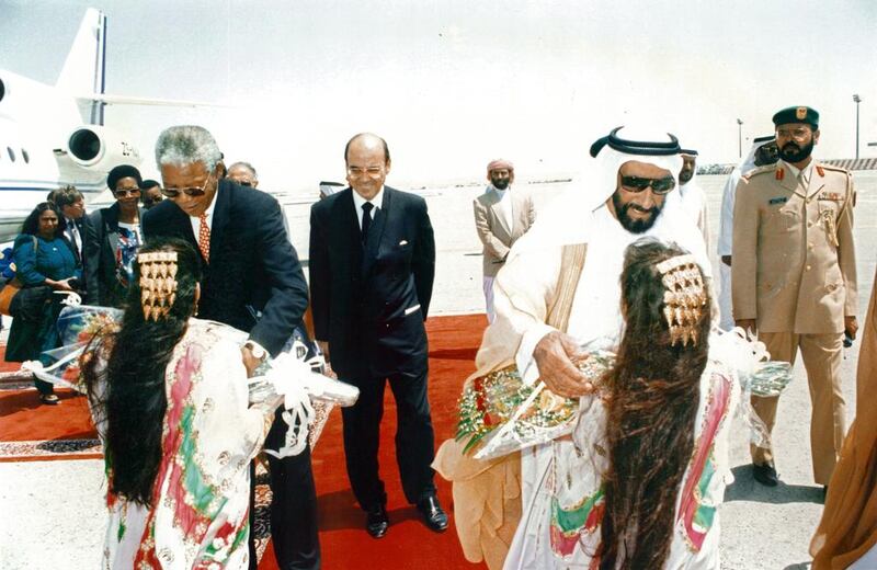 Emirati girls give gifts to Sheikh Zayed and South African president Nelson Mandela during his UAE state visit.