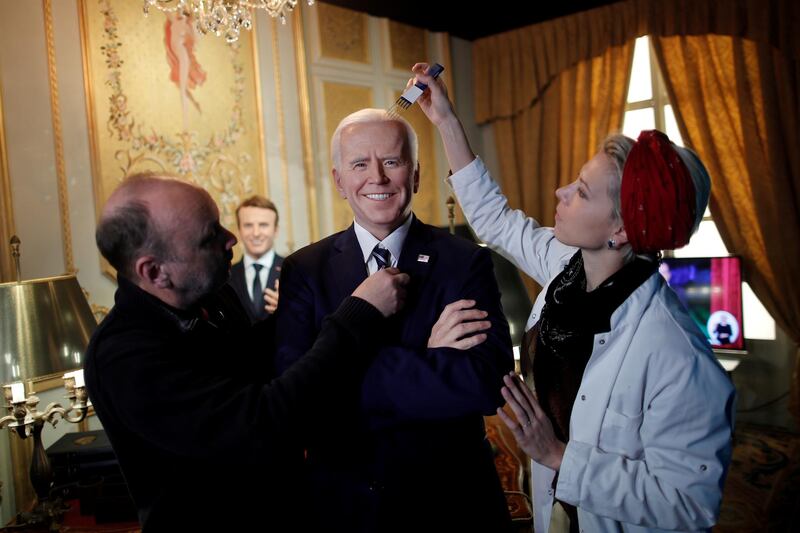 German sculptor Claus Velte and a gallery assistant retouch a waxwork of US President Joe Biden at the Grevin museum in Paris. Reuters