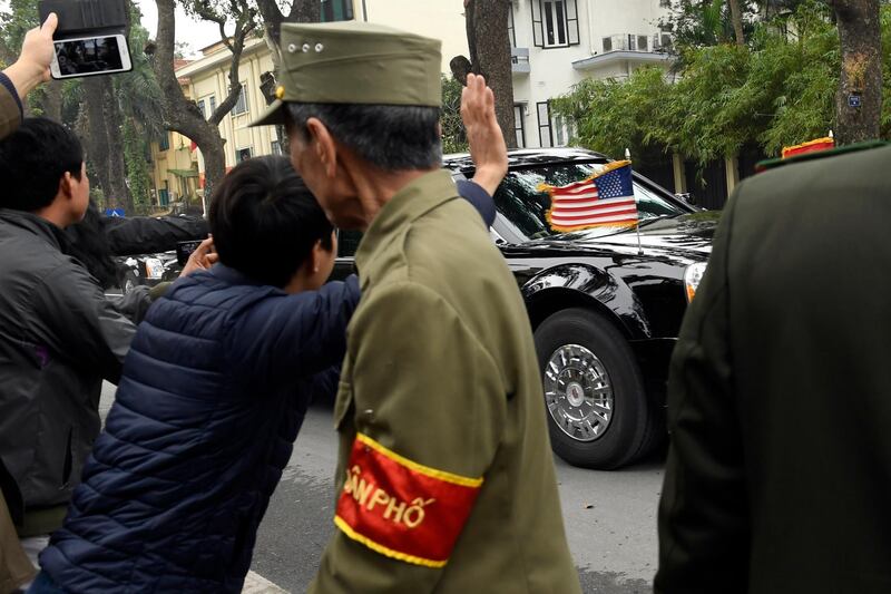 People wave as the motorcade with President Donald Trump makes it way through the streets in Hanoi, Vietnam. AP Photo