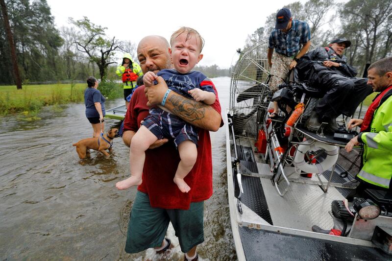 Oliver Kelly, a 1 year old, cries as he is carried off the sheriff's airboat during his rescue from rising flood waters in the aftermath of Hurricane Florence in Leland, North Carolina. Reuters