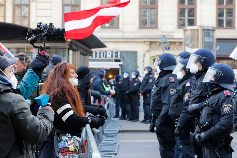 People in Vienna scream at police as officers stop a demonstration against Austria's coronavirus restrictions. AP