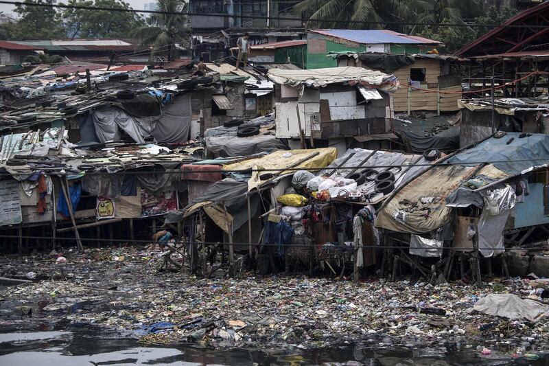 Residents reinforce the roof of their house by putting heavy tires at a slum area in Manila. Noel Celis / AFP