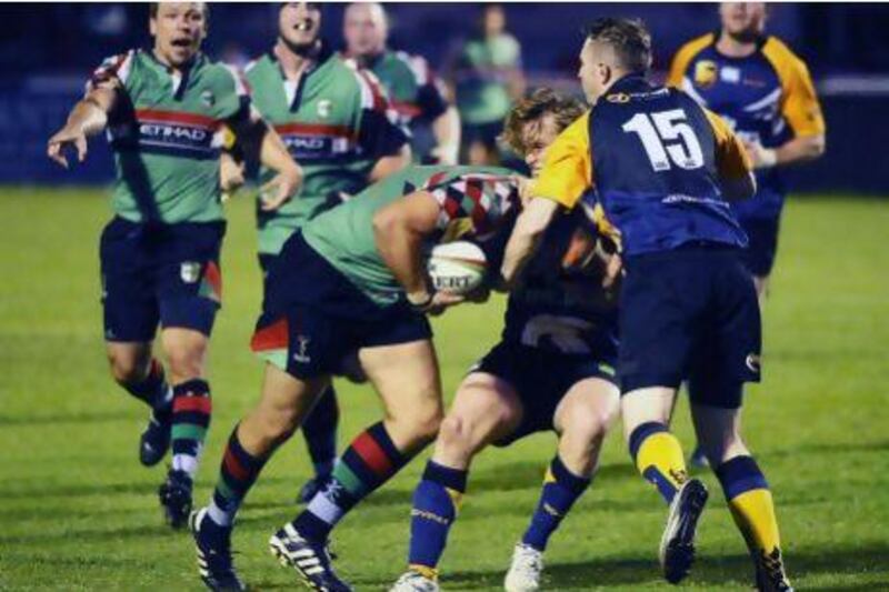 Nick McBride of the Abu Dhabi Harlequins pushes for a try against James Tometski (15) and Chris Gregory of the Dubai Hurricanes. The Quins won 48-24 at The Sevens in Dubai.