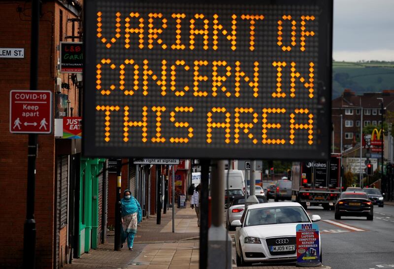 A woman walks past an information sign in Bolton, north-west England, where Covid-19 cases are rising. Reuters