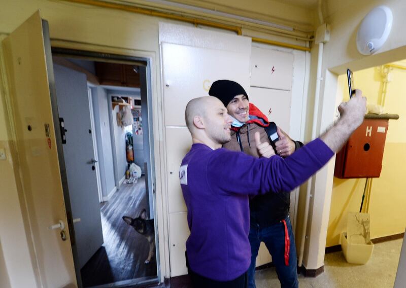 A man takes a selfie with Venezuela's 2012 Olympic champion in fencing, Ruben Limardo Gascon, who has just delivered the food he had ordered through Uber Eats in Lodz, Poland. AP