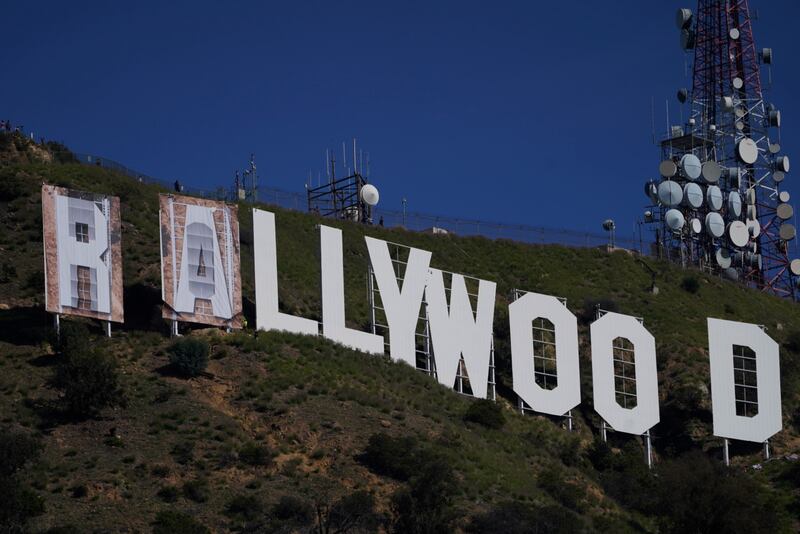 Workers transform the Hollywood sign to read 'Rams House' in Los Angeles on February 14, 2022.  The Hollywood Chamber of Commerce and the Hollywood Sign Trust allowed for making the change to celebrate the Los Angeles Rams' Super Bowl championship. AP Photo