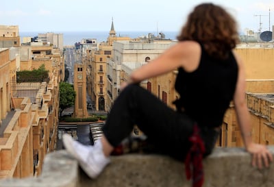 A woman sits atop of a building overlooking Nejmeh square as its entrance was blocked by the army during an anti-government protest in downtown Beirut, Lebanon October 20, 2019. REUTERS/Ali Hashisho