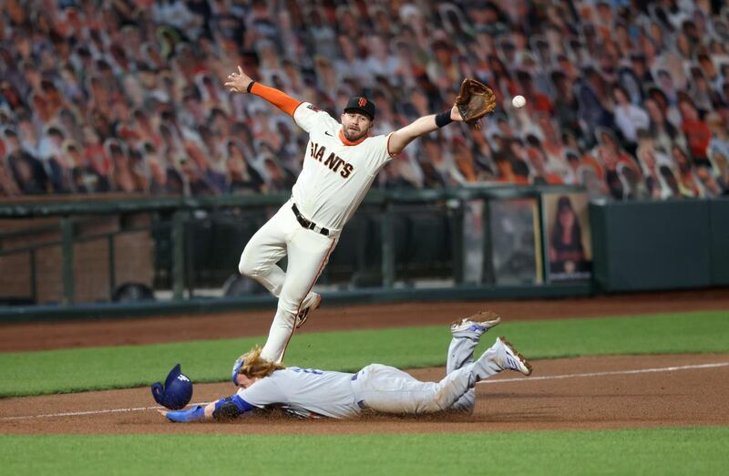 Los Angeles Dodgers' Justin Turner safely steals third base as the ball gets past Evan Longoria of the San Francisco Giants in the Major League Baseball match at Oracle Park on Tuesday, August 25. AFP