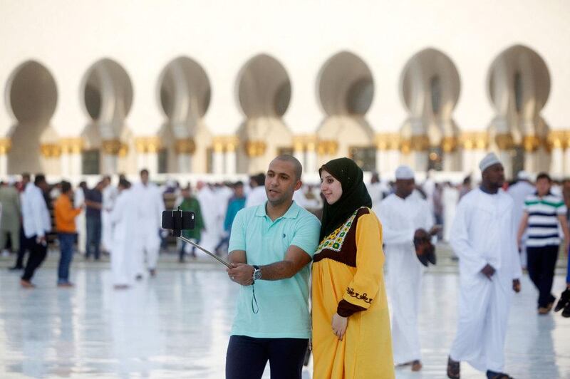A man and a woman take a selfie inside the Sheikh Zayed Grand Mosque. Christopher Pike / The National