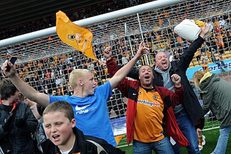Wolves fans celebrate on the Molineux pitch after staying up despite a defeat to Blackburn.