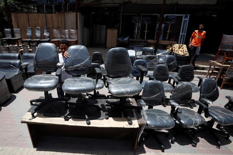 A Palestinian man displays office chairs for sale outside a store, in Ramallah in the occupied West Bank. Reuters