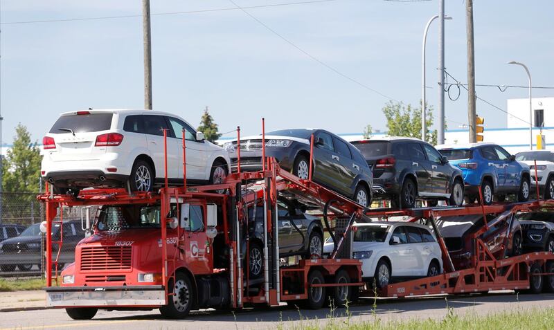 FILE PHOTO: A car hauler transports Chrysler vehicles to a holding lot from the FCA Jefferson North Assembly Plant in Detroit, Michigan, U.S. May 25, 2018.  REUTERS/Rebecca Cook/File Photo
