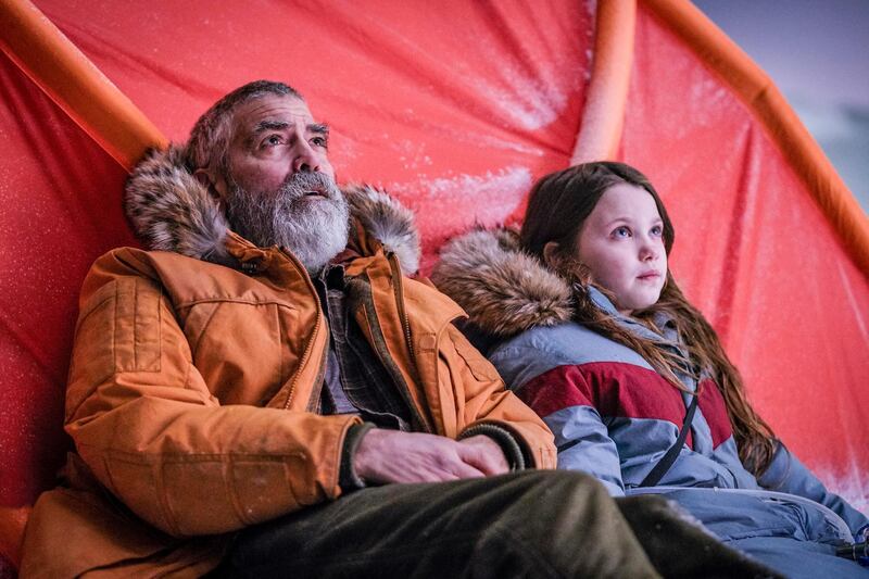 This image released by Netflix shows Caoilinn Springall, right, and George Clooney in a scene from "The Midnight Sky." (Philippe Antonello/Netflix via AP)