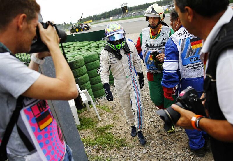 Williams Formula One driver Felipe Massa of Brazil walks off the track after crashing in the first corner after the start of the German Grand Prix at the Hockenheim circuit on July 20, 2014. Kai Pfaffenbach / Reuters