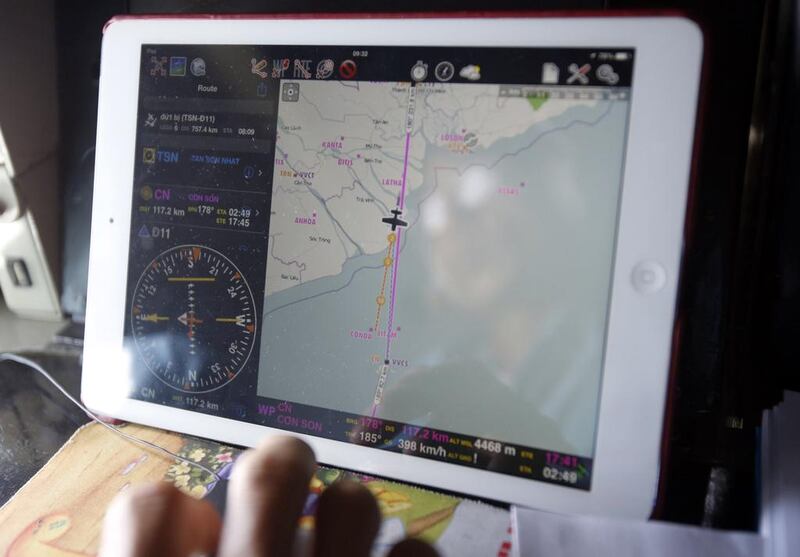 Military officer Ngo Ngoc Dong is seen reflected in a map on an iPad showing the path of the Vietnam Air Force search. Kham / Reuters March 12