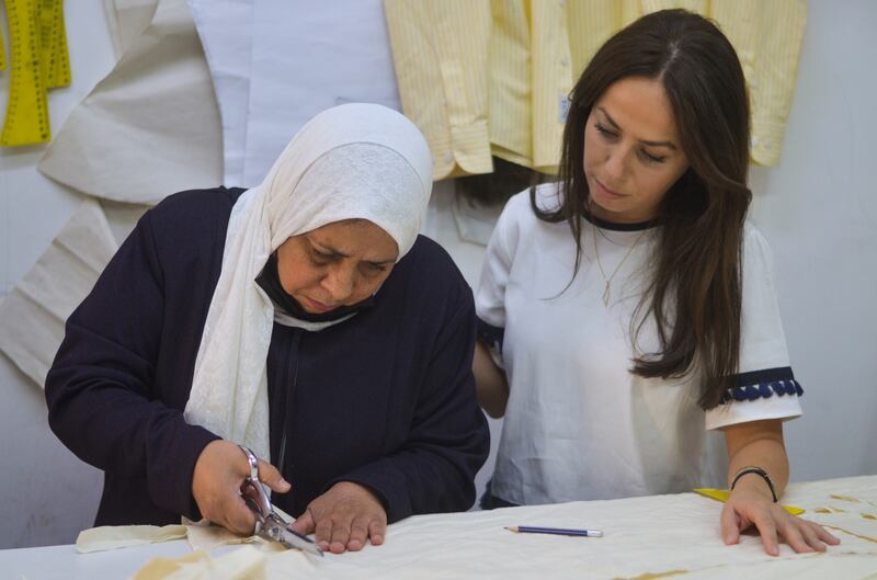 Ms Qaoud and Um Hussein design a traditional doll.