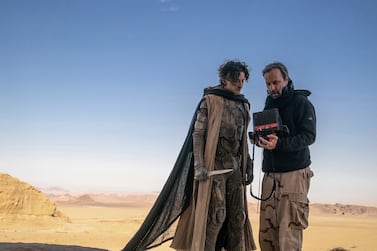 This image released by Warner Bros.  Pictures shows director Denis Villeneuve, right, with actor Timothee Chalamet on the set of "Dune: Part Two. " (Niko Tavernise/Warner Bros.  Pictures via AP)