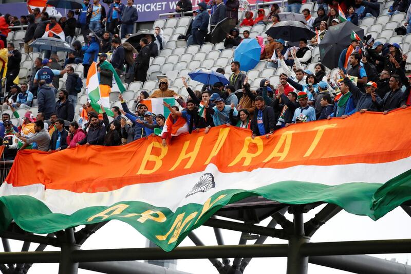 Fans unfurl a huge flag as rain stops play. Action Images via Reuters