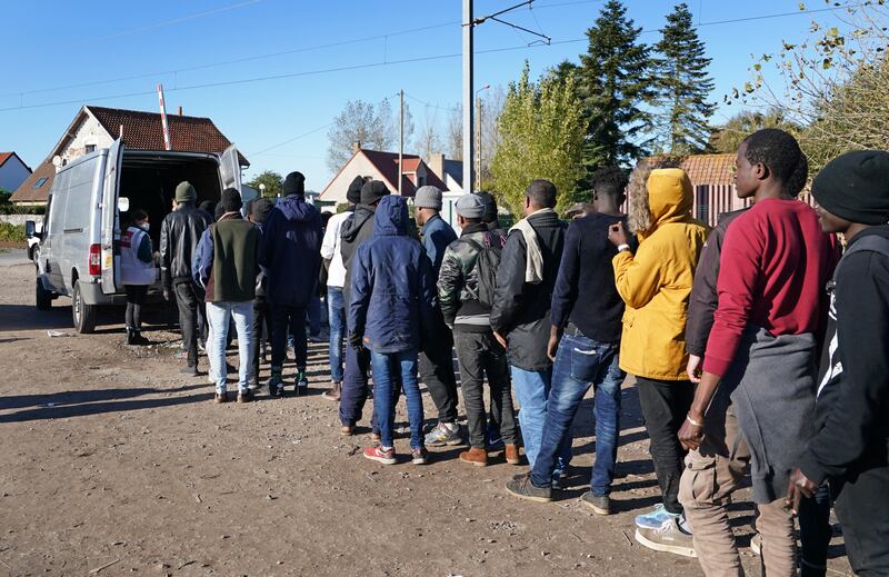 Migrants queue for food at a makeshift camp in Calais, France, as attempts to reach the UK across the Channel continue. PA