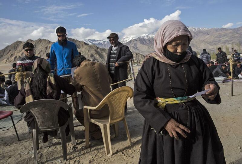 Indian election workers check voting machines before leaving a central collection point for polling stations.