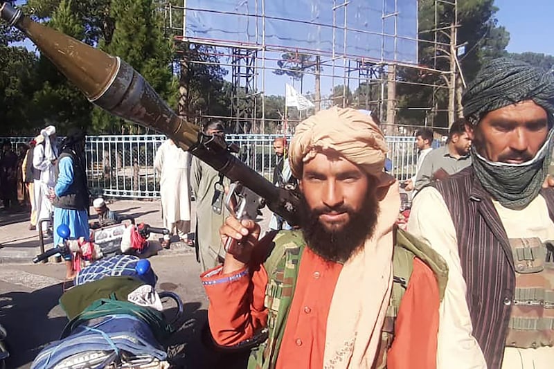 A Taliban fighter brandishes a rocket-propelled grenade launcher in Herat, Afghanistan's third-biggest city, after besieged government forces pulled out.