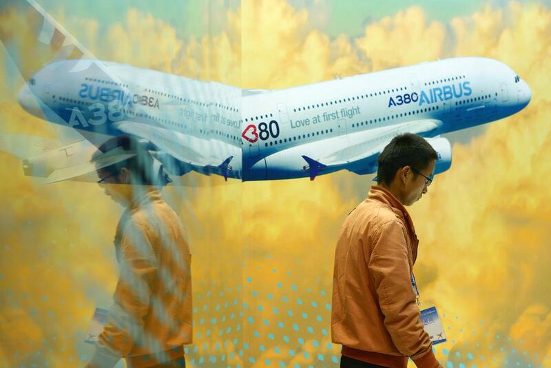 A man walks past an Airbus A380 poster at the Beijing International Aviation Expo in Beijing. The company sees demand for its superjumbo growing in the long term. Wang Zhao / AFP