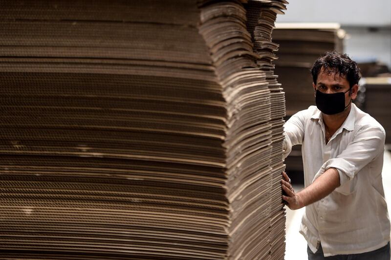 A worker pushing piles of cardboards used to make cardboard beds for COVID-19 coronavirus patients at a factory at Bhiwadi in the state of Rajasthan. India is deploying thousands of beds made of cardboard to makeshift medical facilities as it struggles to deal with the surging number of coronavirus cases.  AFP