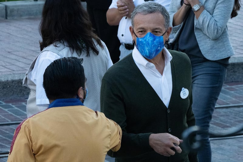 Bob Iger, chairman of Walt Disney Co., elbow-bumps an employee during the reopening of the Disneyland theme park in Anaheim, California, U.S., on Friday, April 29, 2021. Walt Disney Co.'s original Disneyland resort in California is sold out for weekends through May, an indication of pent-up demand for leisure activities as the pandemic eases in the nation's most-populous state. Photographer: Bing Guan/Bloomberg