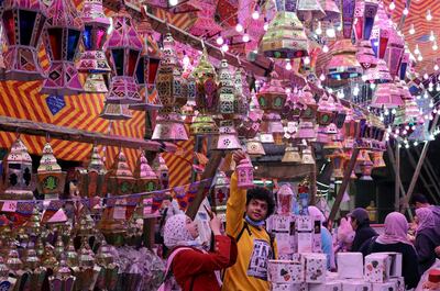 People take a photo of a traditional Ramadan lantern called "fanous" at a shop stall ahead of the Muslim holy month of Ramadan, amid the coronavirus disease (COVID-19) pandemic in Cairo, Egypt, April 8, 2021. REUTERS/Mohamed Abd El Ghany