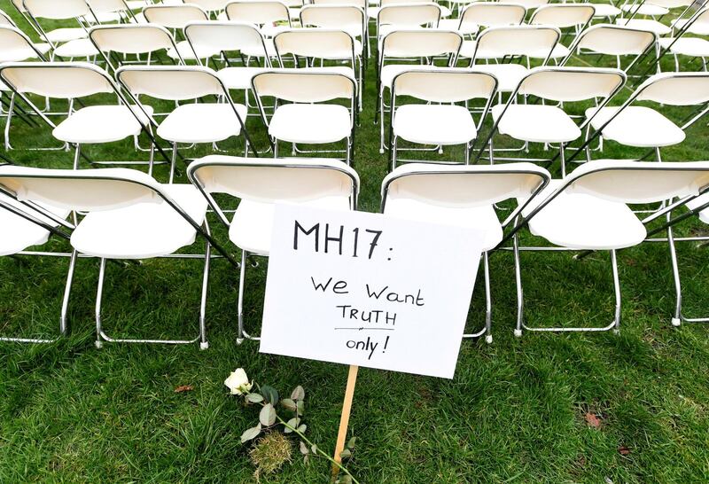 A protest sign in front of a row of empty chairs lined up outside the Russian Embassy in The Hague, Netherlands on March 8, 2020 by family members of victims of the MH17 crash. Each chair represents a seat on the plane. Reuters