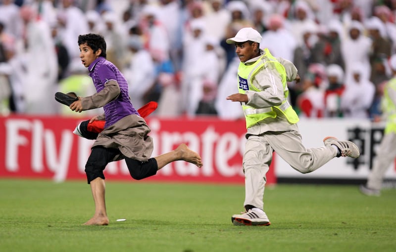 February 22, 2012 (Abu Dhabi)A UAE fan runs out on the field chased by security after the UAE National team won their Olympic qualifier against Australia game play in Abu Dhabi February 22, 2012.  (Sammy Dallal / The National)
