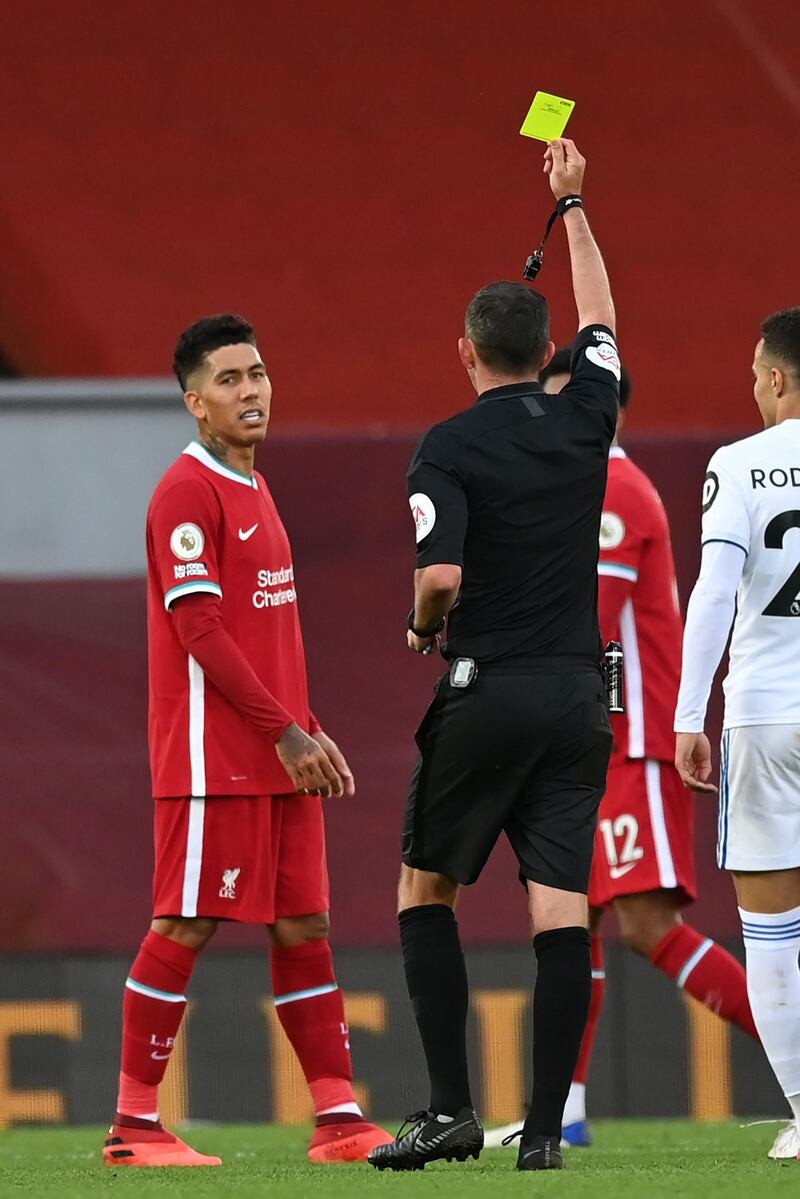 Referee Michael Oliver shows Liverpool's Roberto Firmino a yellow card. AFP