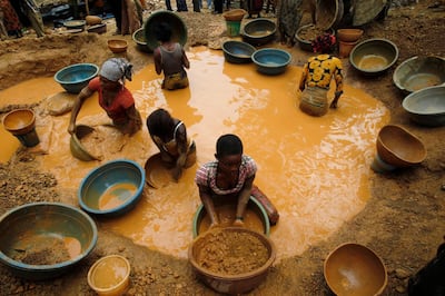 Prospectors pan for gold at a new gold mine found in a cocoa farm near the town of Bouafle in western Ivory Coast March 18, 2014. With high prices for the precious metal fuelling a gold rush in Ivory Coast and Ghana, diggers are scurrying to cash in. But the drain on the labour market and the harm done to cocoa plantations could endanger cocoa production in the two nations, which account for 60 percent of global supply. Picture taken March 18, 2014. To match Insight COCOA-GOLD/WESTAFRICA    REUTERS/Luc Gnago (IVORY COAST - Tags: AGRICULTURE BUSINESS COMMODITIES EMPLOYMENT TPX IMAGES OF THE DAY) - GM1EA4B10GU01