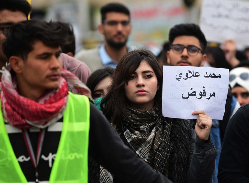 An Iraqi university student carries a placard reading in Arabic 'Mohamed Allawi is rejected' during a strike and protests in central Baghdad.  EPA