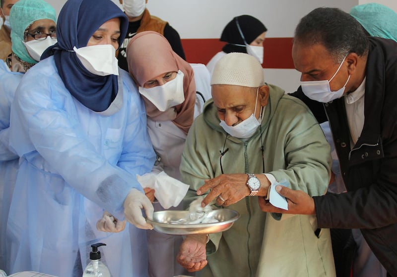 Healthcare workers assist an elderly man after he received the Covid-19 vaccine in Sale. Reuters