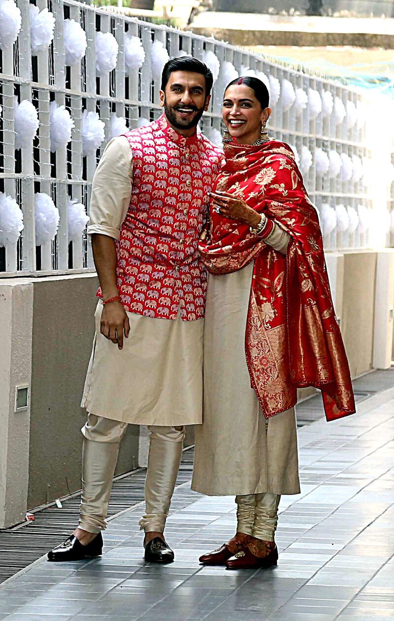 Indian Bollywood actors and recently-wedded couple Ranveer Singh (L) and Deepika Padukone pose after arriving at their residence in Mumbai on November 18, 2018 after being married in Lake Como. Photo / AFP