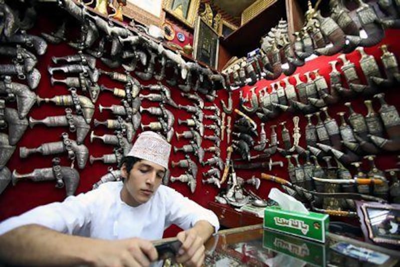 An Omani Khanjar (dagger) seller sits inside his shop at the traditional Souk Muttrah in Muscat, Oman. EPA / ALI HAIDER